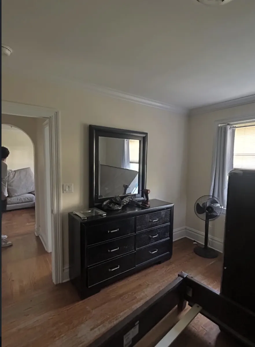 Bedroom with dresser, mirror and furniture before removal