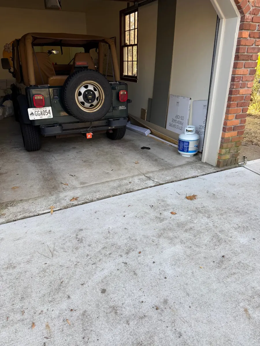Several mattresses stacked in a garage ready for removal — after