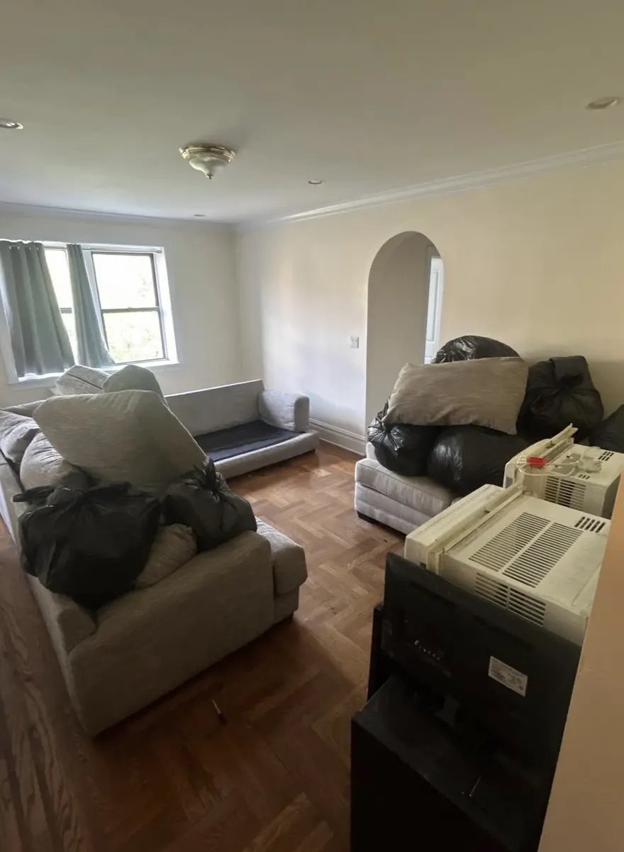 Living room with sofas, bags and air conditioners before removal